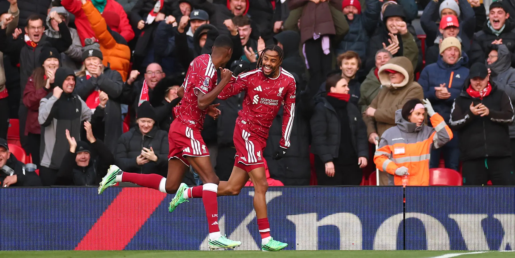 Dos jugadores de Liverpool festejan un gol ante la hinchada.